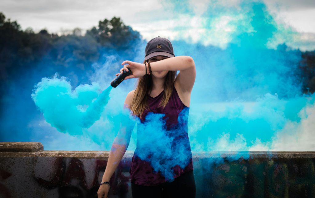 pexels photo 445109 445109 A stylish woman surrounded by bright blue smoke outdoors, creating a dynamic fashion statement.