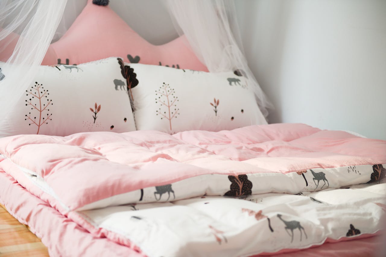 A cozy bedroom with pink bedding and animal patterns, perfect for relaxation.