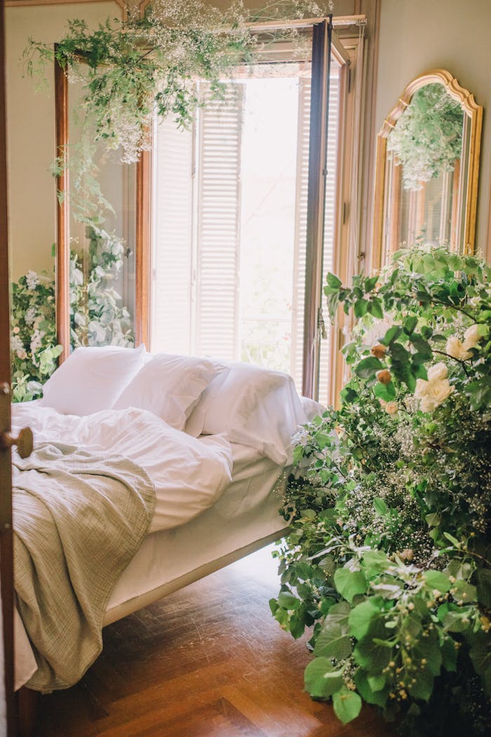 A tranquil bedroom adorned with vibrant greenery and soft natural light, evoking a peaceful retreat.